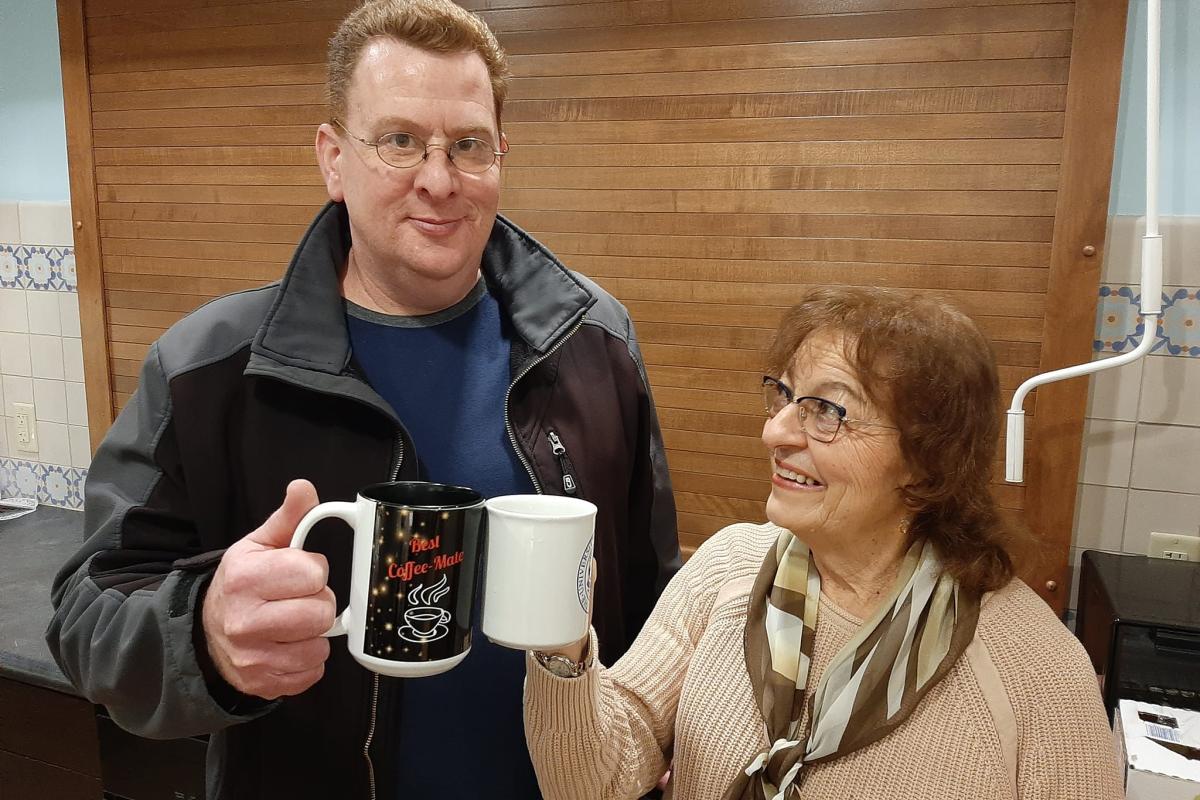 Man and woman toast with coffee mugs