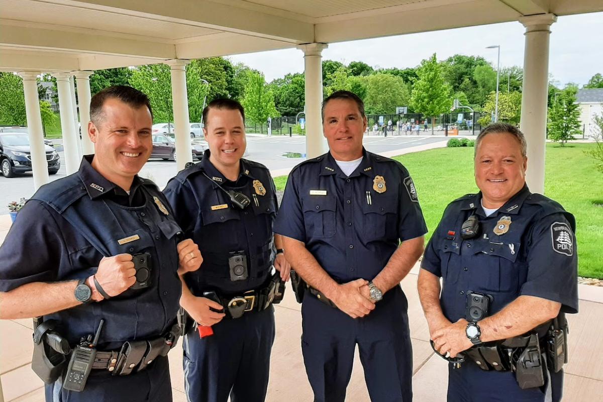 Four uniformed police officers line up for a photo under a portico