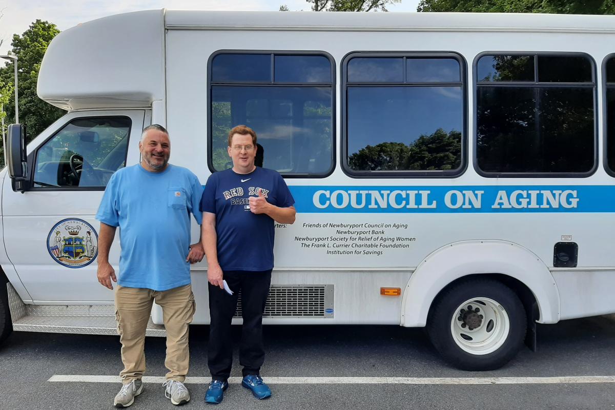 Two men stand in front of Council on Aging Bus