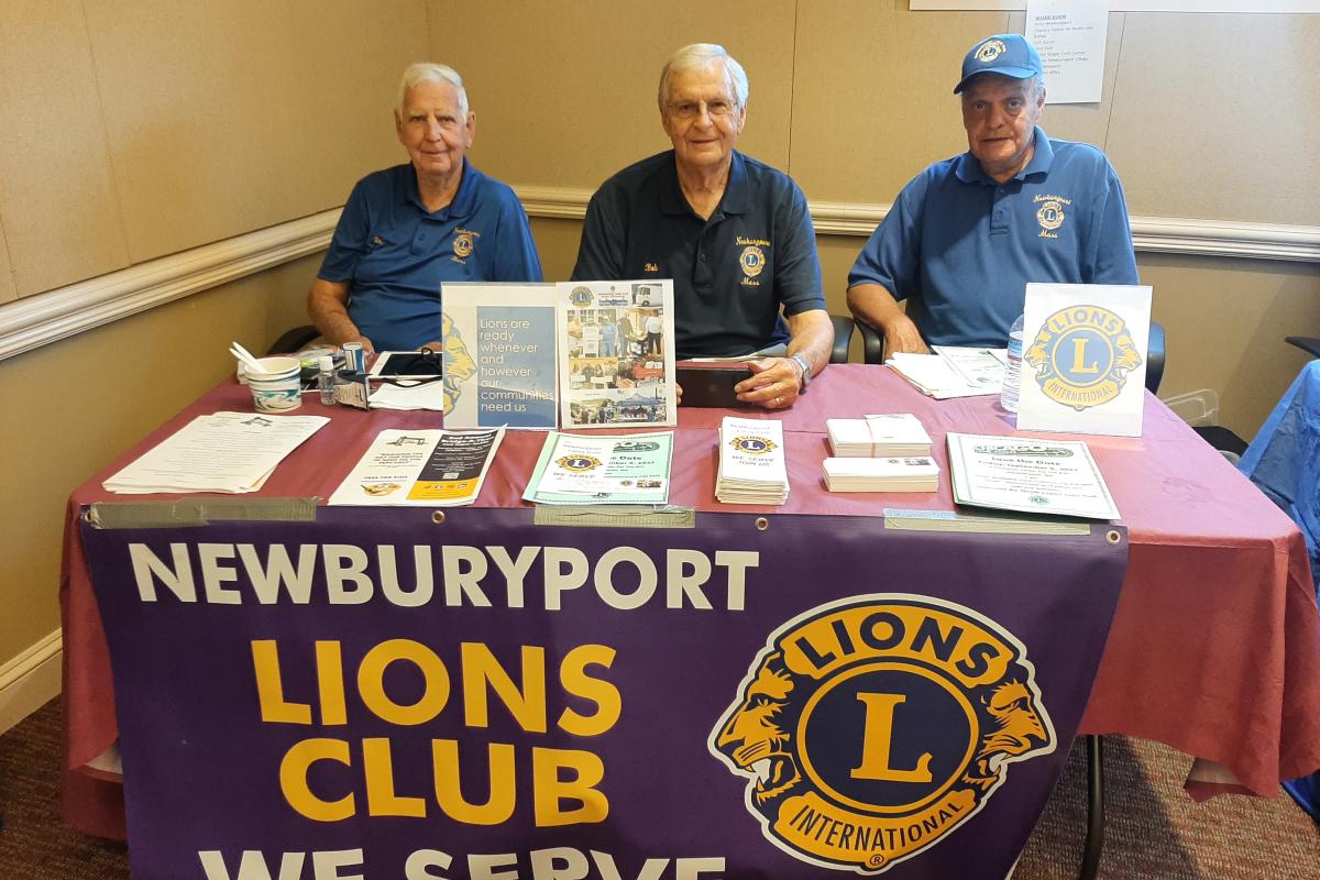 Three men staff a table for the Newburyport Lions Club