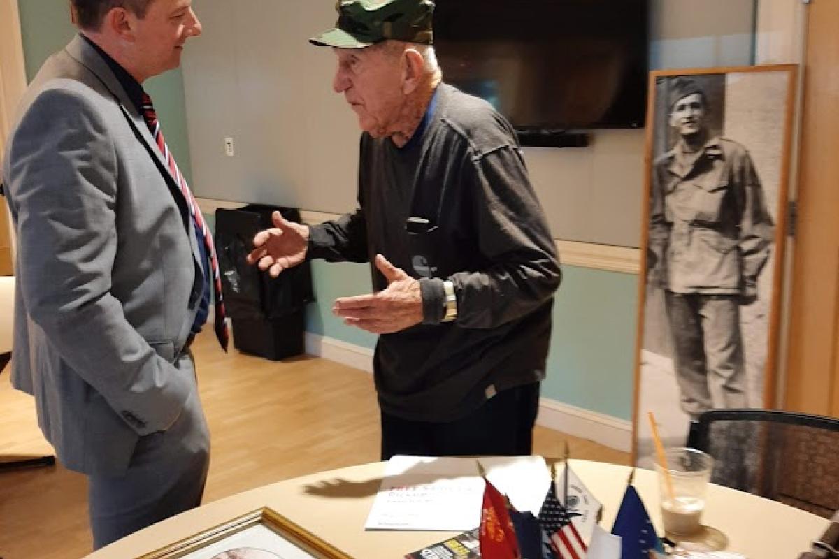 A veteran speaks with a man about a display that he created in anticipation of Veterans Day