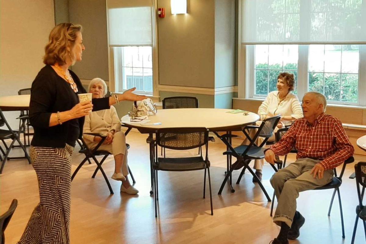 A woman speaks to a small group of engaged audience members