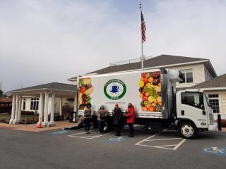 Truck in front of building with food pantry volunteers